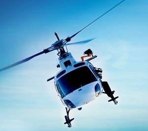 Helikopter flyr hyttematerialer i hengende last til hyttetomt